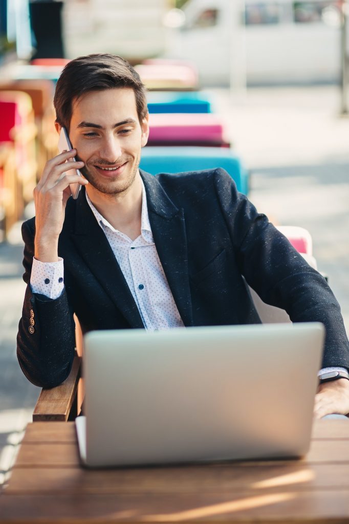 Young entrepreneur working on laptop and phone